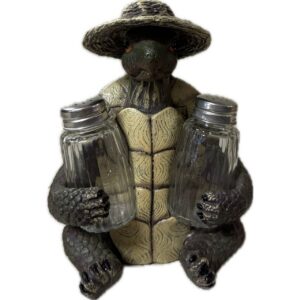 Ceramic turtle figurine wearing a wide hat, holding two glass salt and pepper shakers.