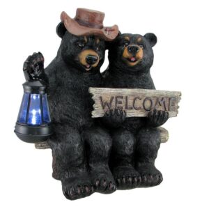 Decorative bear figurines sitting together, holding a 'WELCOME' wooden sign with a lantern on the side (garden decor).